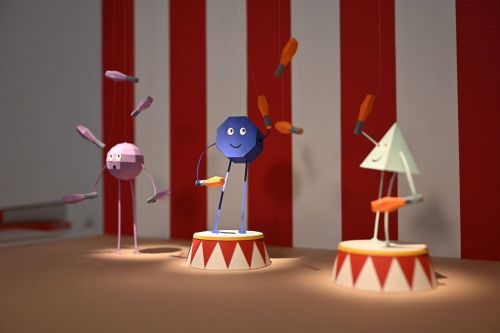 Behind the scenes photo of a selection of paper shape characters juggling. 